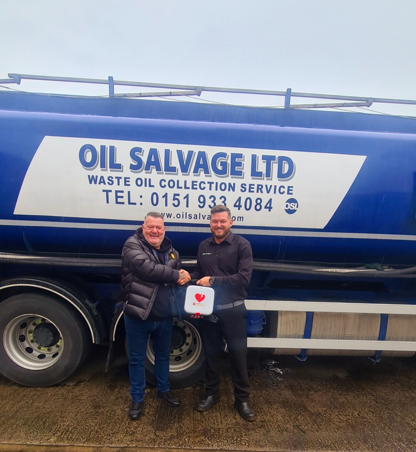 Mark King from the Oliver King Association issuing a defibrillator to our Compliance Manager Neil